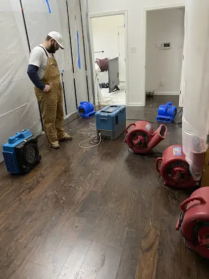 Restoration technician checking air movers and containment during a Cordova dry-out