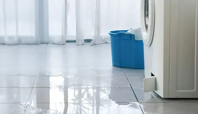 Water spread across a tile floor from a leaking washing machine in Cordova